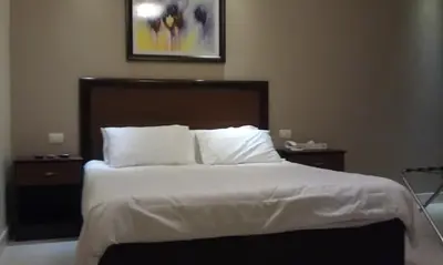 a bedroom with a large bed with white sheets and pillows at Salome Hotel in Madaba