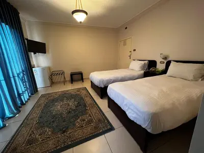 a hotel room with two beds and a rug at Salome Hotel in Madaba