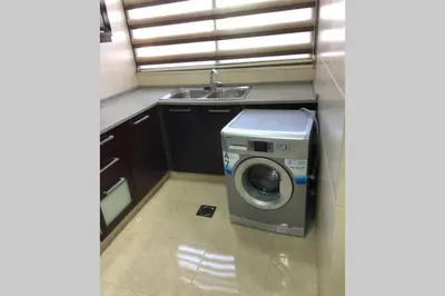 a washing machine in a kitchen next to a sink at Apt 4 rent/A quiet neighborhood close to services in Amman