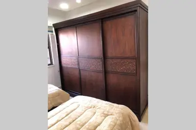 a bedroom with a large wooden closet with a bed at Apt 4 rent/A quiet neighborhood close to services in Amman