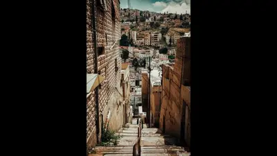 a person walking down an alleyway between two buildings at Superior Executive Apartment in Umm Uthainah