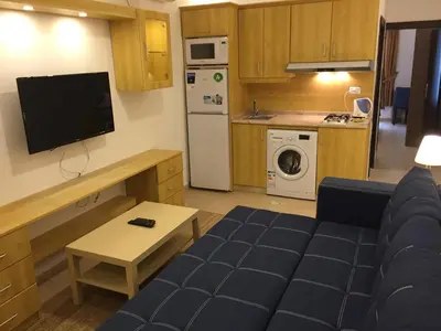 a living room with a couch and a kitchen at Superior Executive Apartment in Umm Uthainah