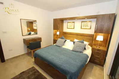 a hotel room with a bed and a chair in it at The Royal Luxury Superior King in Amman