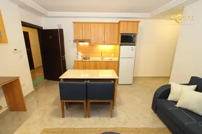 a kitchen and a living room with a table and a couch at The Royal Luxury Superior King in Amman