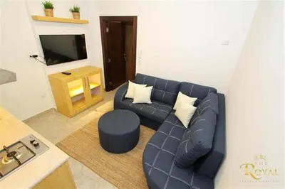a living room with a blue couch and a television at The Royal Luxury City Budget Visit in Amman