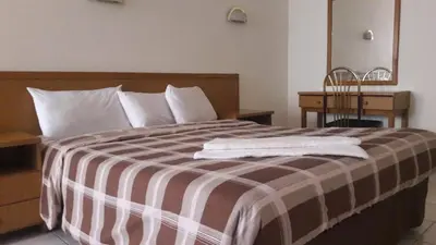 a bed with a brown and white blanket on it at Razan Hotel in Amman