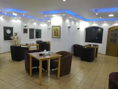 a waiting room with couches and tables and a television at Razan Hotel in Amman