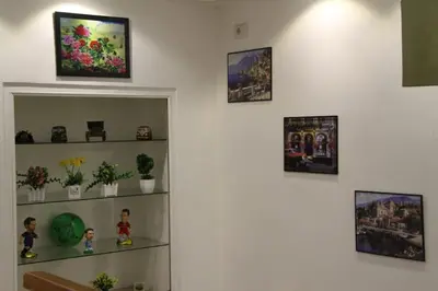 a shelf with plants and pictures on a wall at Razan Hotel in Amman