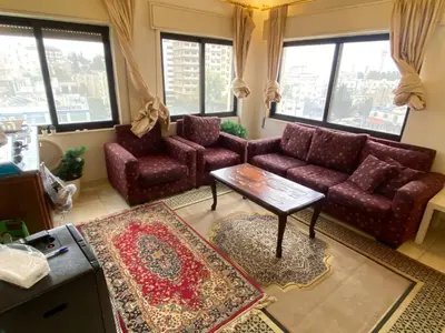 a living room with couches and a table and windows at ROYAL Real ESTATE in Amman