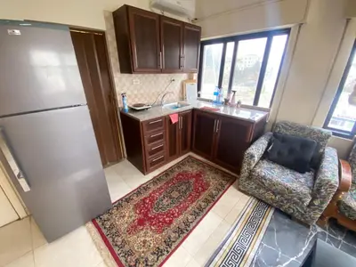a kitchen with a refrigerator and a chair at ROYAL Real ESTATE in Amman