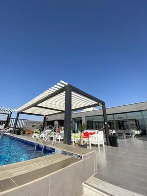 a pavilion with chairs and a pool on a building at Mass Paradise Hotel in Aqaba