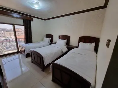 a hotel room with two beds and a window at Nahas Plaza in Irbid
