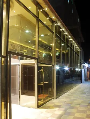 a large glass building with a revolving door at night at Nahas Plaza in Irbid