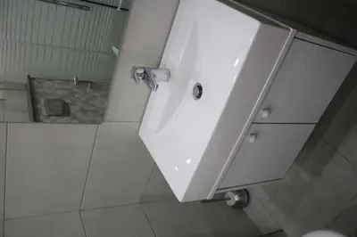 a bathroom with a white sink and a shower at Amazing one Bedroom Apartment in Amman Elwebdah 7 in Amman