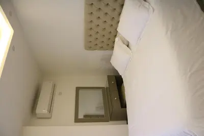 an attic room with a bed and a mirror at Amazing one Bedroom Apartment in Amman Elwebdah 7 in Amman