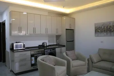 a kitchen with two chairs and a microwave in it at Amazing one Bedroom Apartment in Amman Elwebdah 7 in Amman