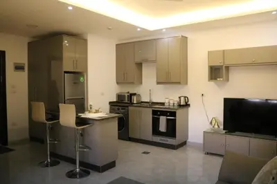 a kitchen with a counter and some chairs in it at Amazing one Bedroom Apartment in Amman Elwebdah 7 in Amman