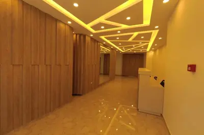 a hallway with wood paneled walls and a hallway with yellow lights at Amazing one Bedroom Apartment in Amman Elwebdah 3 in Amman