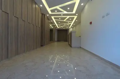 a hallway of an office building with lights on the ceiling at Amazing one Bedroom Apartment in Amman Elwebdah 3 in Amman