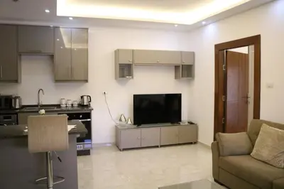 a living room with a couch and a television at Amazing one Bedroom Apartment in Amman Elwebdah 8 in Amman