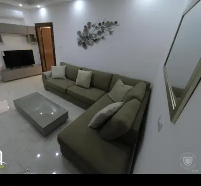 a living room with a couch and a table at Amazing one Bedroom Apartment in Amman Elwebdah 8 in Amman