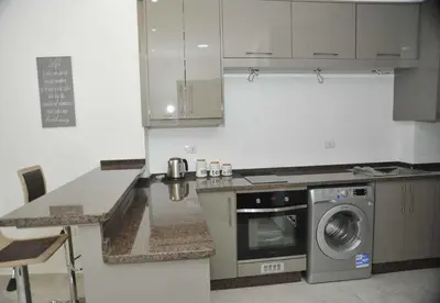 a kitchen with a stove and a washing machine at Amazing one Bedroom Apartment in Amman Elwebdah 2 in Amman