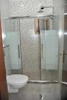 a bathroom with a shower and a toilet at Amazing one Bedroom Apartment in Amman Elwebdah 2 in Amman