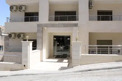 a large white building with a balcony at Amazing one Bedroom Apartment in Amman Elwebdah 5 in Amman
