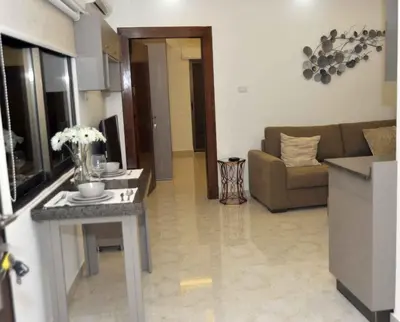 a living room with a couch and a table at Amazing one Bedroom Apartment in Amman Elwebdah 6 in Amman