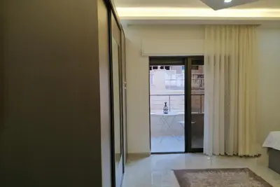 a hallway with a door leading into a room at Amazing one Bedroom Apartment in Amman Elwebdah 1 in Amman
