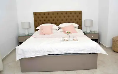 a bedroom with a large bed with pink pillows at Amazing one Bedroom Apartment in Amman Elwebdah 4 in Amman
