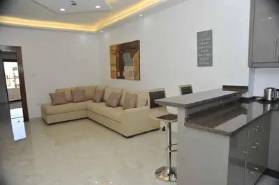 a living room with a couch and a table at Amazing one Bedroom Apartment in Amman Elwebdah 4 in Amman