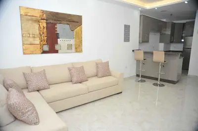 a living room with a couch and a painting on the wall at Amazing one Bedroom Apartment in Amman Elwebdah 4 in Amman