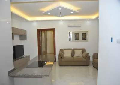 a living room with a couch and a glass table at Amazing one Bedroom Apartment in Amman Elwebdah 4 in Amman
