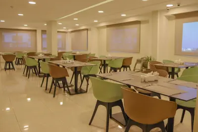 a dining room with tables and chairs and a screen at Twins Boutique Hotel in Aqaba