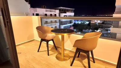 a table and two chairs on a balcony with a view at Twins Boutique Hotel in Aqaba