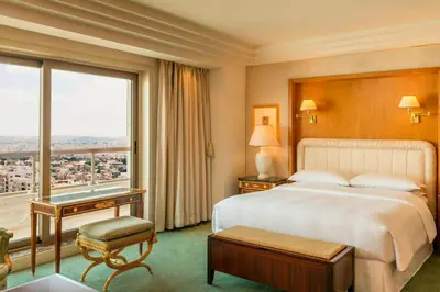 a hotel room with a bed and a large window at Sheraton Amman Al Nabil Hotel in Amman