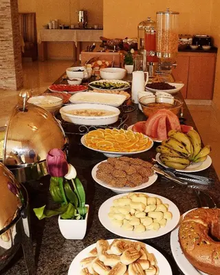 a table full of different types of food on plates at Mosaic City Hotel in Madaba