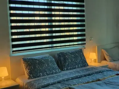 a bedroom with a bed with two pillows and a window at Full Panorama To Archaeological Site Jarash in Jerash