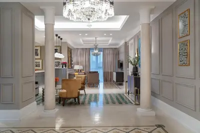 a living room with columns and a chandelier at Landmark Amman Hotel & Conference Center in Amman