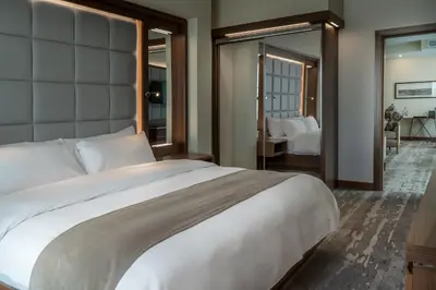 a bedroom with a large white bed and a mirror at Landmark Amman Hotel & Conference Center in Amman