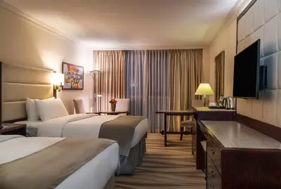 a hotel room with two beds and a television at Landmark Amman Hotel & Conference Center in Amman