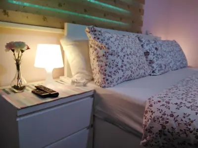 a bed with a night stand with a lamp on it at moon valley site jerash in Jerash