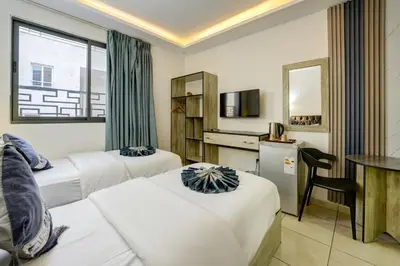 a hotel room with two beds and a desk at Downtown Hotel للعائلات فقط in Aqaba