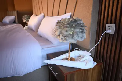 a flower on a night stand next to a bed at Luxury Color Camp in Wadi Rum