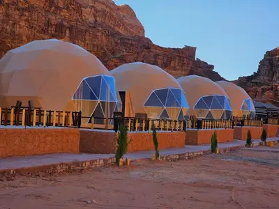 a row of domes with a mountain in the background at Luxury Color Camp in Wadi Rum