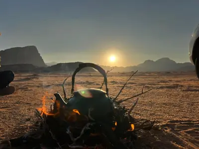 a tea kettle over a camp fire on the beach at Maraheb Luxury camp in Wadi Rum