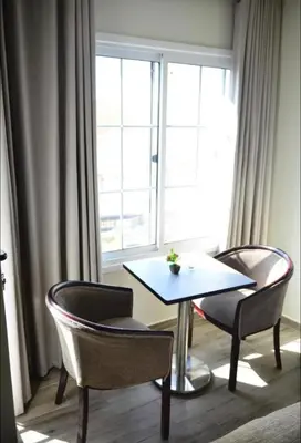a table and chairs in a room with a window at Moses Residence in Wadi Musa