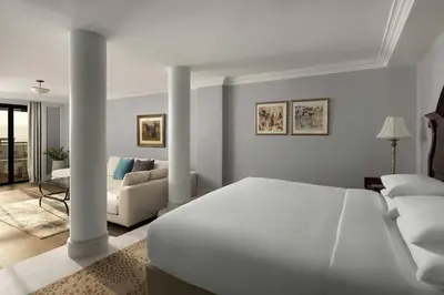 a white bedroom with a bed and a couch at Dead Sea Marriott Resort & Spa in Sowayma