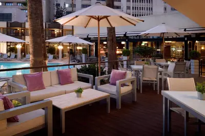 a patio with couches and tables and a pool at Amman Marriott Hotel in Amman